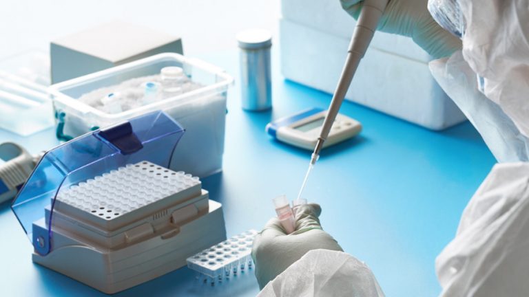 Mains d'une personne travaillant avc une pipette dans un laboratoire Mains d'une personne travaillant avc une pipette dans un laboratoire